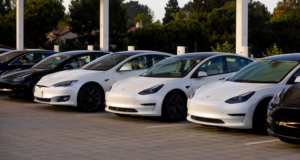 Row of white Teslas of different models parked in a row