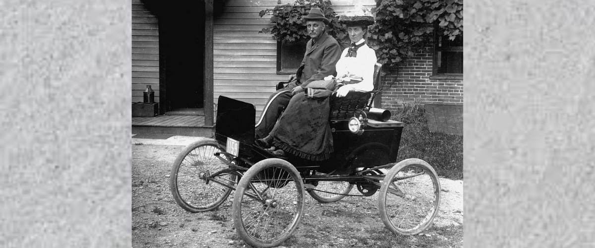 Black and white photo of couple in an early EV